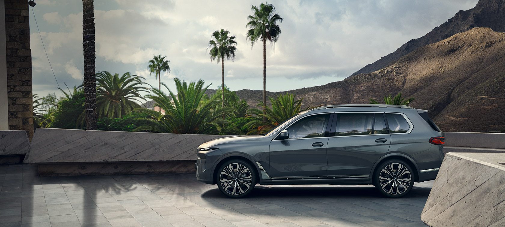 BMW X7 G07 LCI Side View standing in front of trees Sparkling Copper Grey metallic